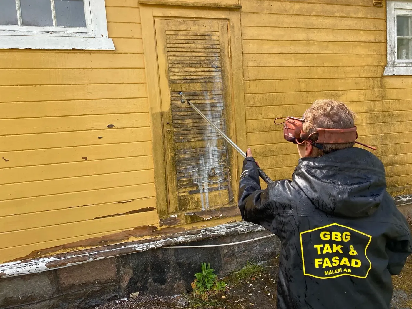 Grundlig fasadtvätt av en gul trävilla inför målning